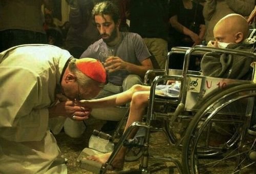 O então Cardeal Bergoglio, agora Papa Francisco, lavando os pés a um pequeno em cadeira de rodas
