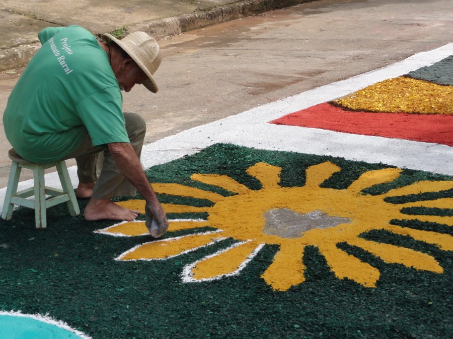 Voluntário faz tapete para a procisão